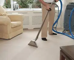 Carpet cleaning professional removing dirt and stains with a hot-water extraction tool in a home, Spokane, WA.
